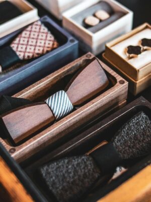 A collection of wooden bow ties displayed elegantly in a drawer, showcasing luxury menswear accessories.