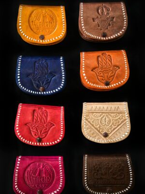 A vibrant collection of handmade leather bags displayed against a black background.