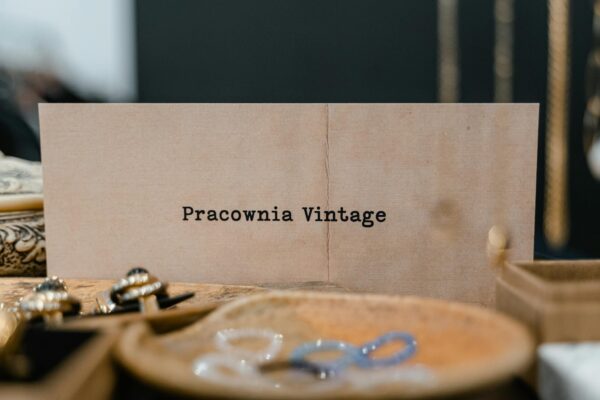 Close-up of a vintage jewelry display with a 'Pracownia Vintage' card label.