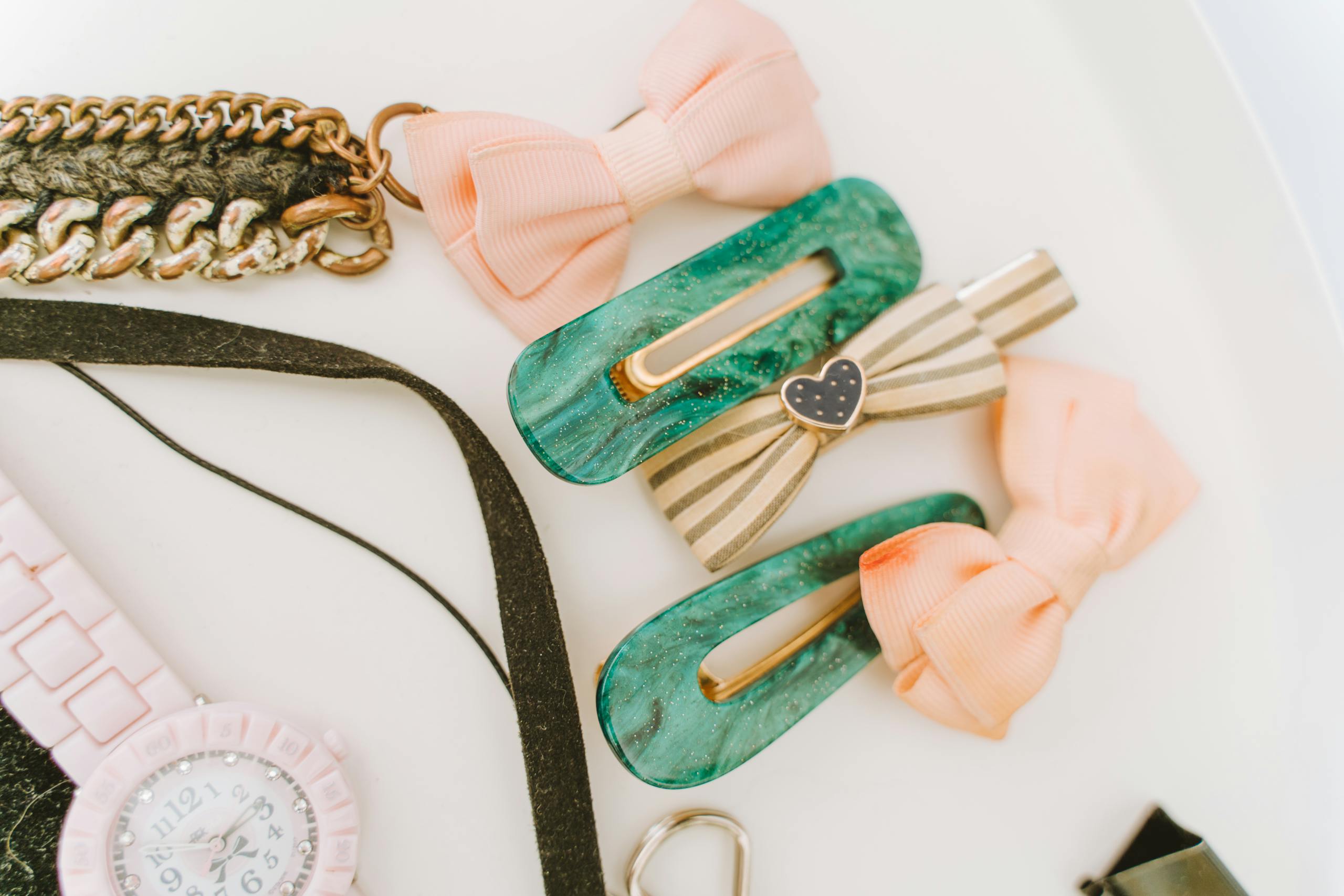 Elegant collection of hair clips, bows, and wristwatch on a white background. Perfect for fashion and accessory themes.