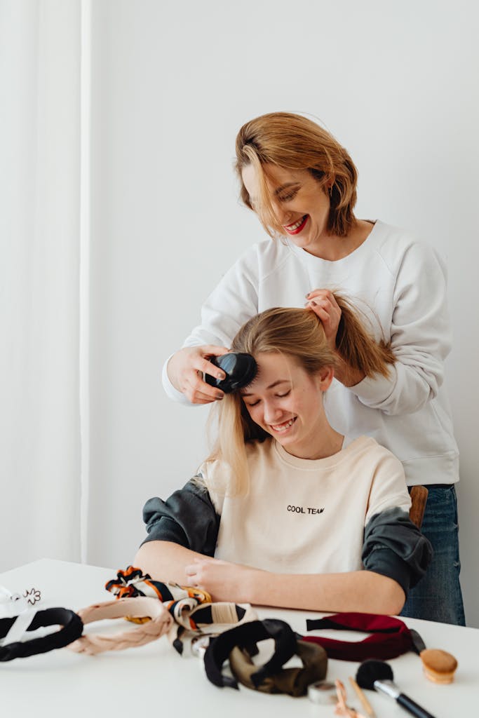 Speaking Life While You Braid: What to Say During Morning Hair Time 7 Happy mother styling her daughter's hair in a bright and cozy room.