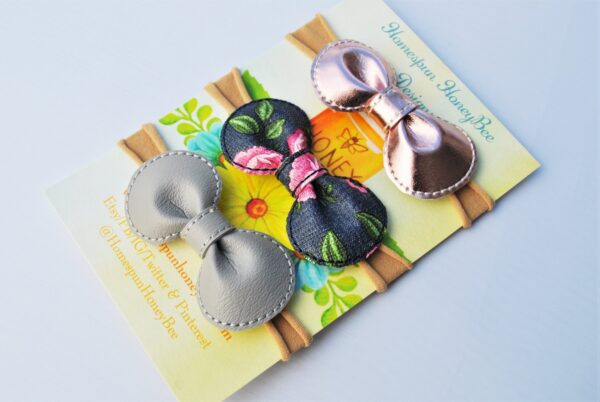 set of 3 baby bow headbands featuring a grey bow, a denim look floral bow, and a rose gold metallic bow by homespun honeybee designs