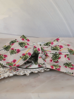 Alyce Pretty Posies Flat Linen fabric Alyce Bow from flat angle on marble slab.