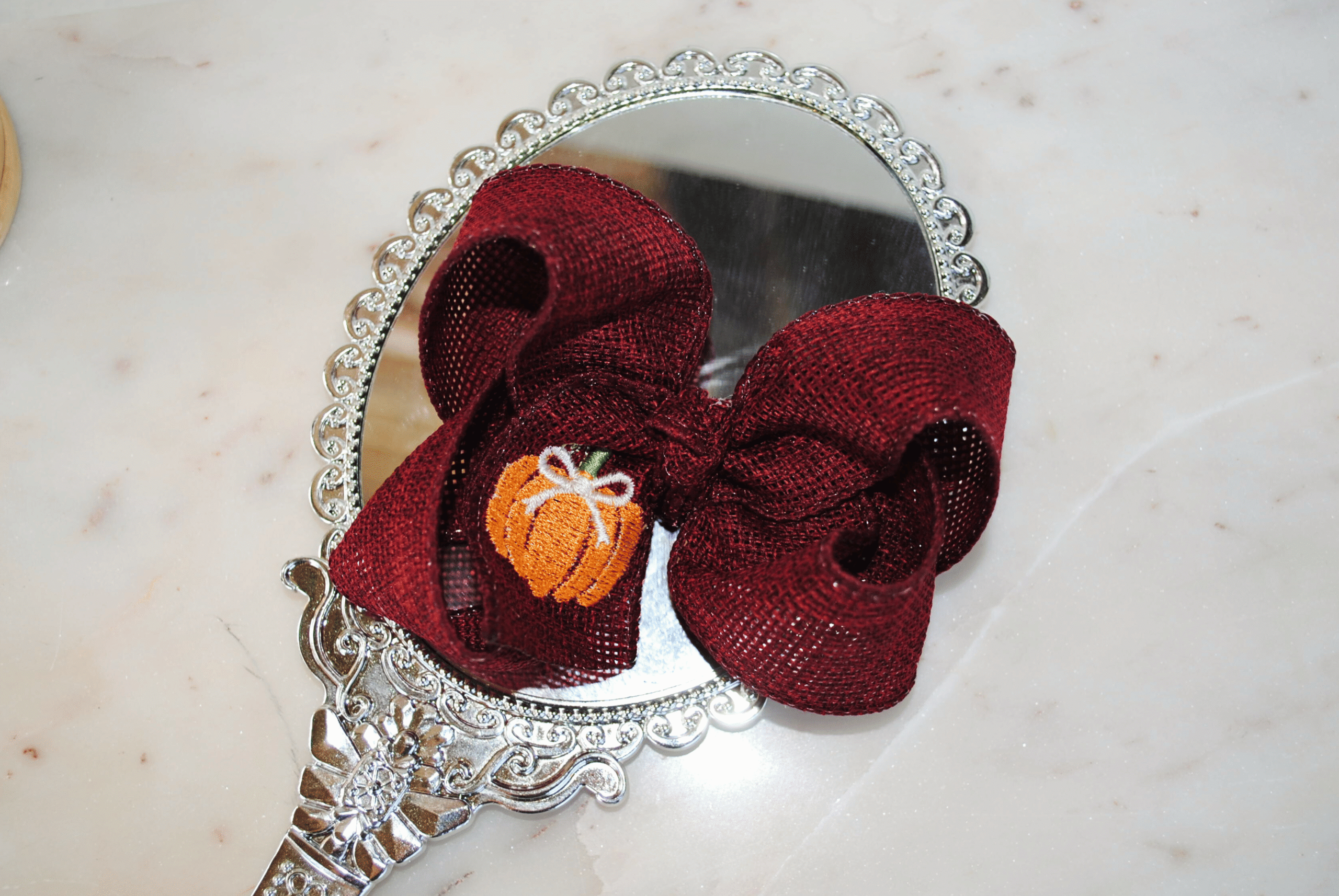 close up boutique pumpkin bow crafted from cranberry burlap ribbon.