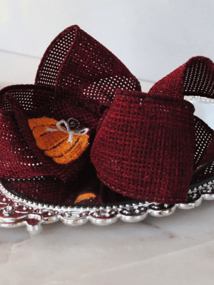 Cranberry Burlap Pumpkin Bow Side view of pumpkin bow that has been stitched on cranberry burlap.