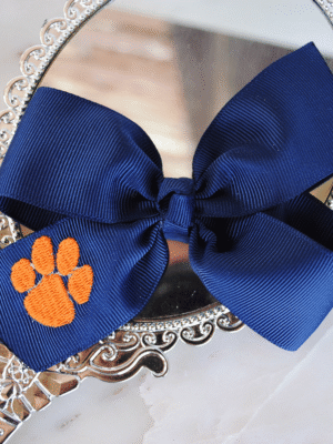 Flat navy pinwheel bow with embroidered paw print