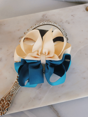 Flat lay of two tone honeycomb ribbon bow in ivory and peacock blue