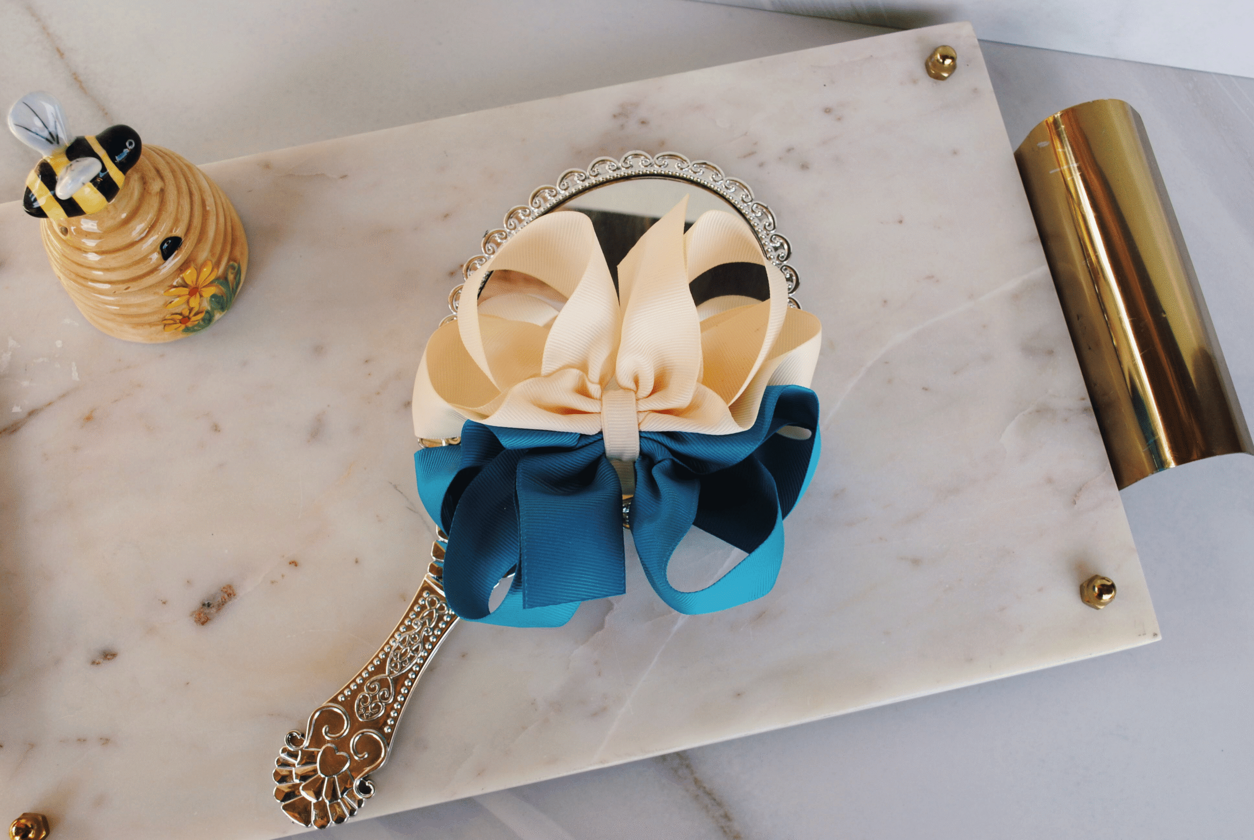 Flat lay of two tone honeycomb ribbon bow in ivory and peacock blue