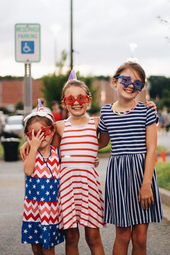 Children in festive attire celebrating Fourth of July with smiles and fun.