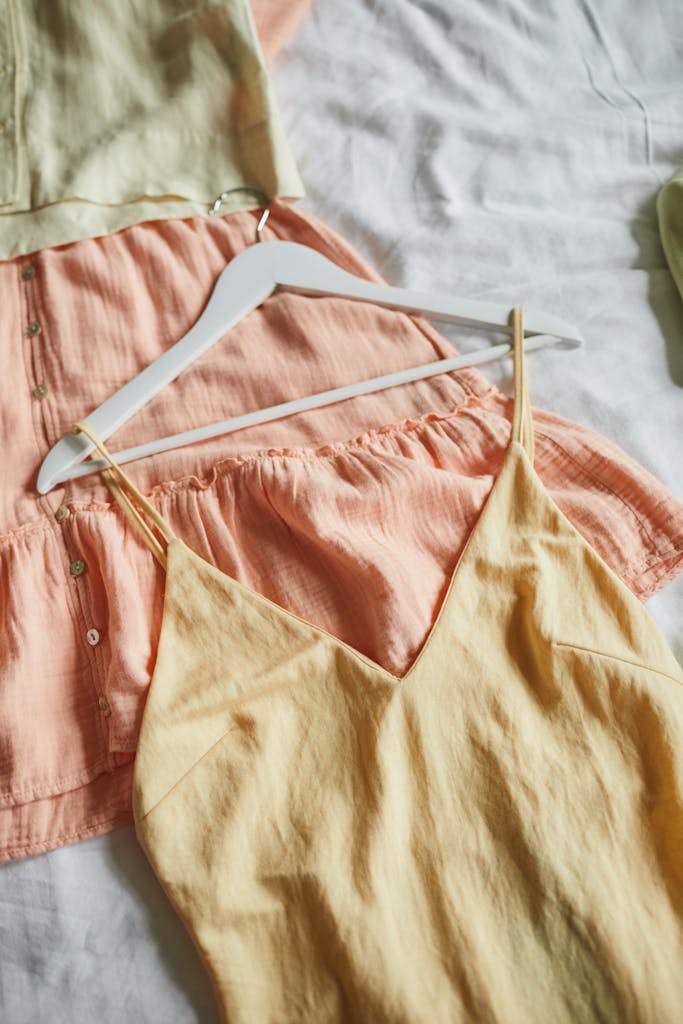 Close-up of stylish pastel dresses on hangers, ideal for summer fashion inspiration.