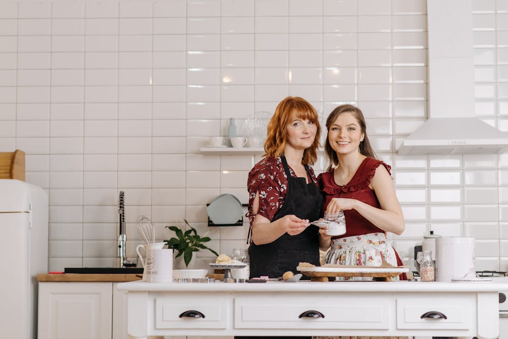 Smiling mother and daughter bonding while baking in modern kitchen.