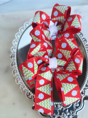 Festive Christmas trees on red ribbon pigtail bows