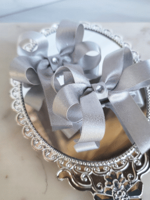 A pair of elegant silver satin pigtail bows with rhinestone center
